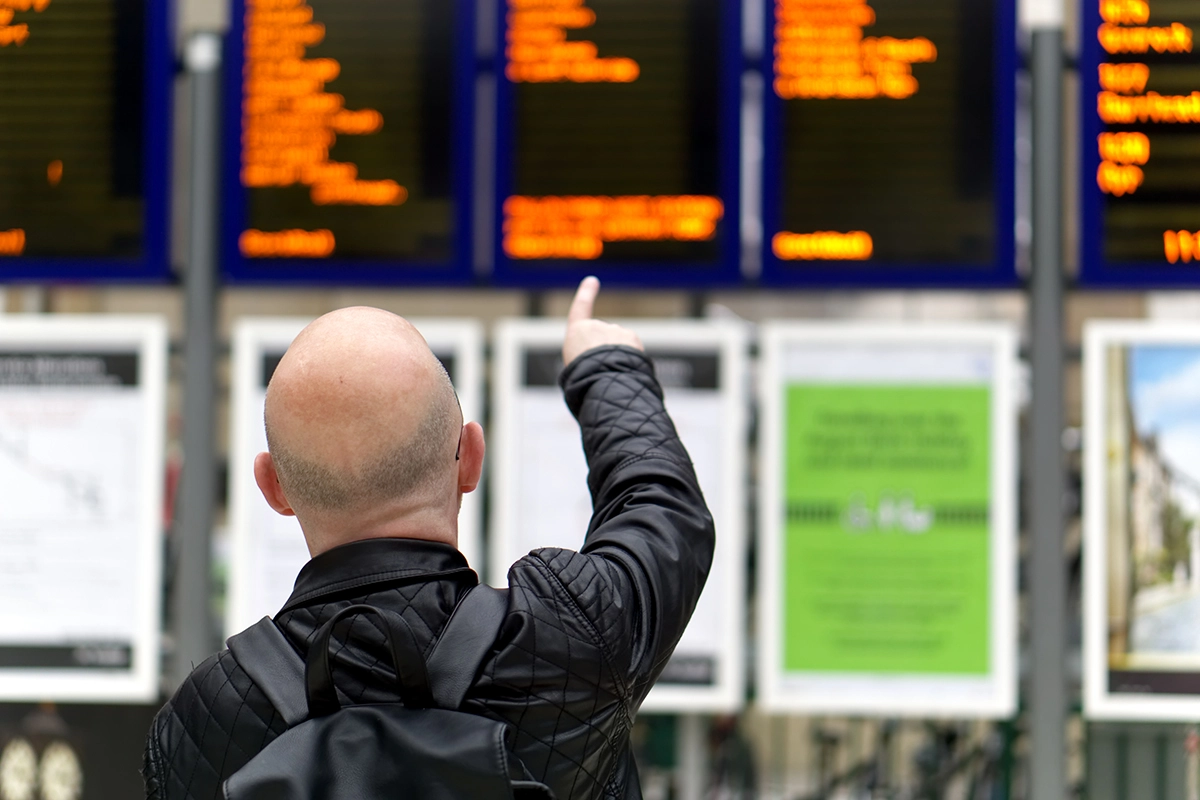 Man pointing at departure board at Glasgow Central