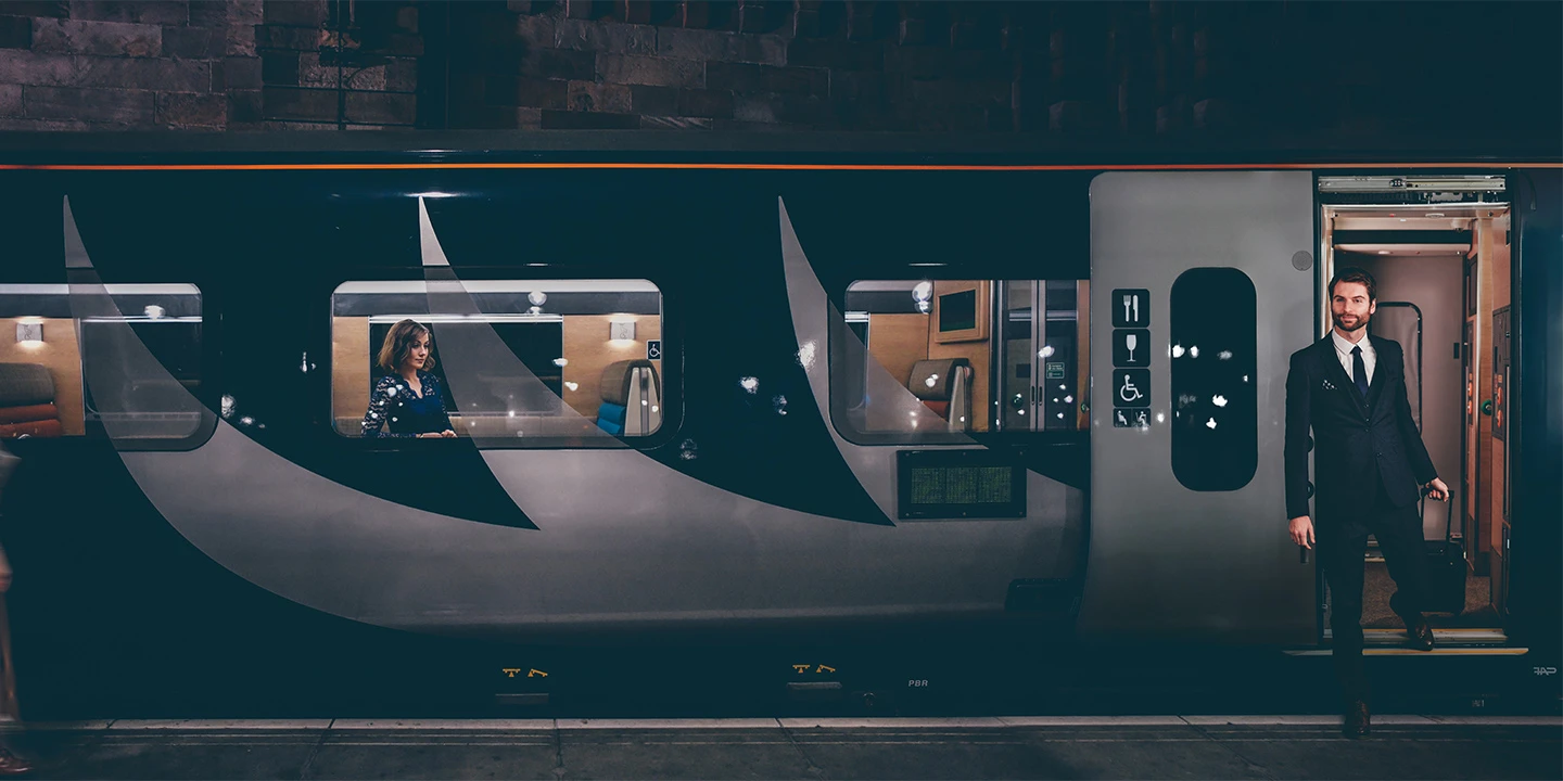 Man coming out of door on Caledonian Sleeper on to platform 