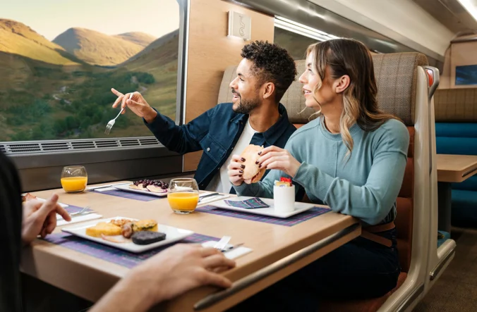 Couple enjoying a meal onboard the Caledonian Sleeper.