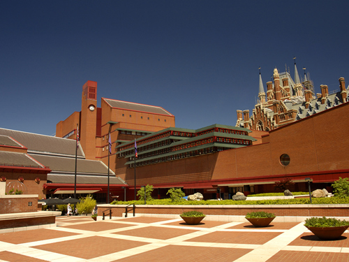 View of the courtyard of the british Library, London, with the gothic towers of St Pancras Station peeping over the top at the right. Space for text in the clear blue sky.