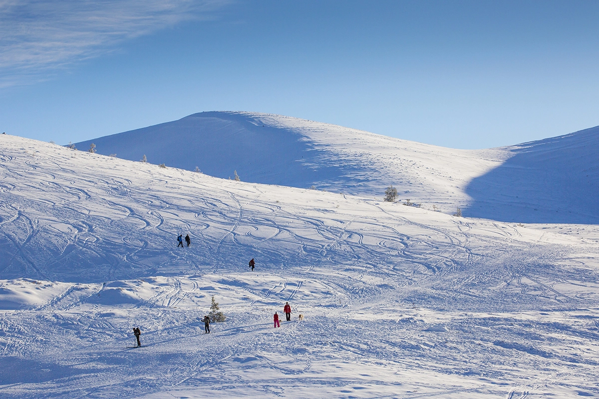 Snow on Cairngorm mountains with people skiing