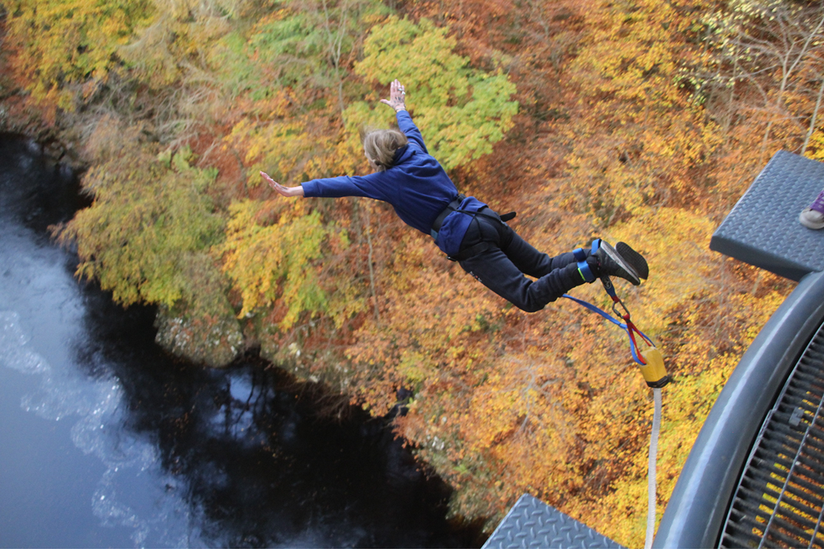 Person bungee jumping over gorge
