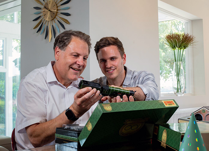 Two men inspecting a new Hornby model train. 