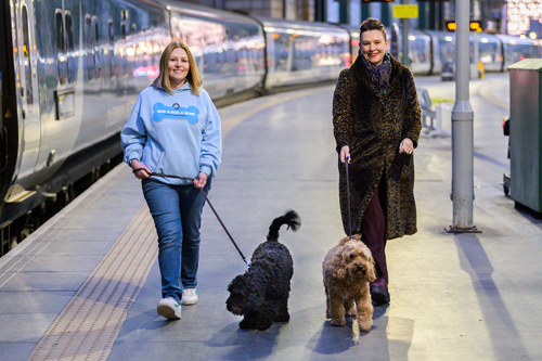 Managing Director of Caledonian Sleeper, Kathryn Darbandi and Louise Russell, founder, trustee and chief executive of Give A Dog A Bone with two dogs at Glasgow Central