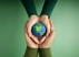 Embrace of hands holding miniature planet Earth