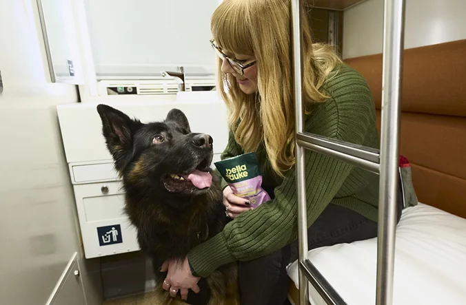 Woman and dog in a Caledonian Sleeper room with her dog.