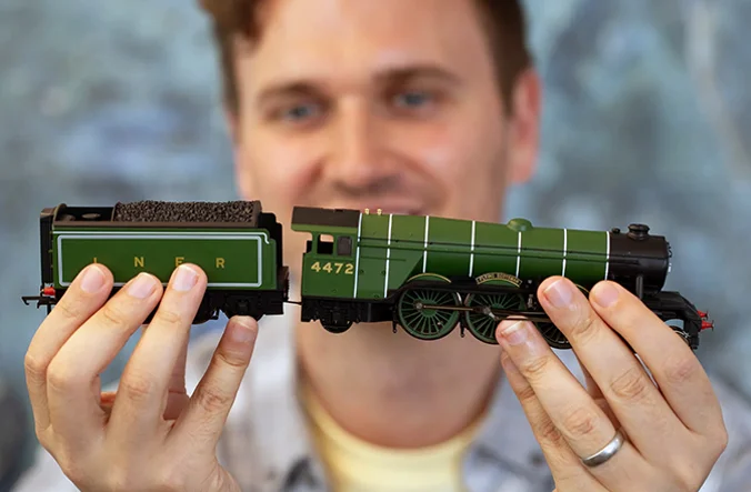 Man holding a Hornby model train.