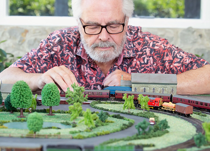 Older man with glasses working on model railway