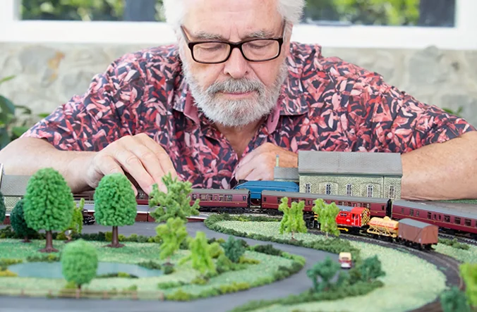 Older man with glasses working on model railway