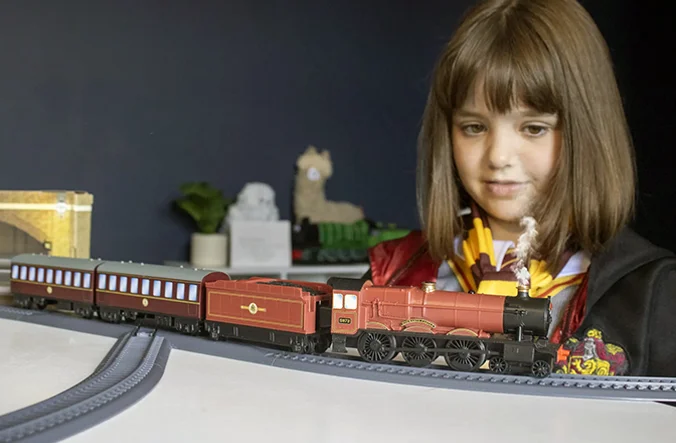 Young child looking at their model of the Hogwarts Express train.